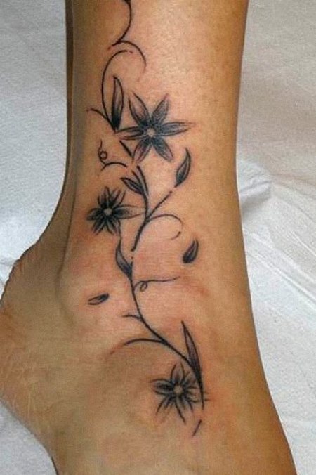 graceful black and grey tattoo having a single flower and vine,